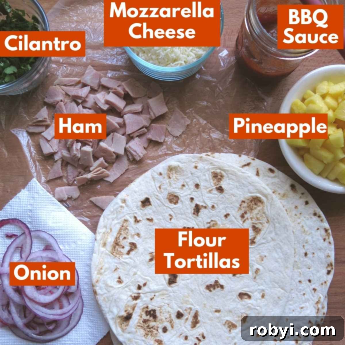 A selection of fresh ingredients including ham, pineapple, red onion, and mozzarella cheese laid out for making quesadillas.