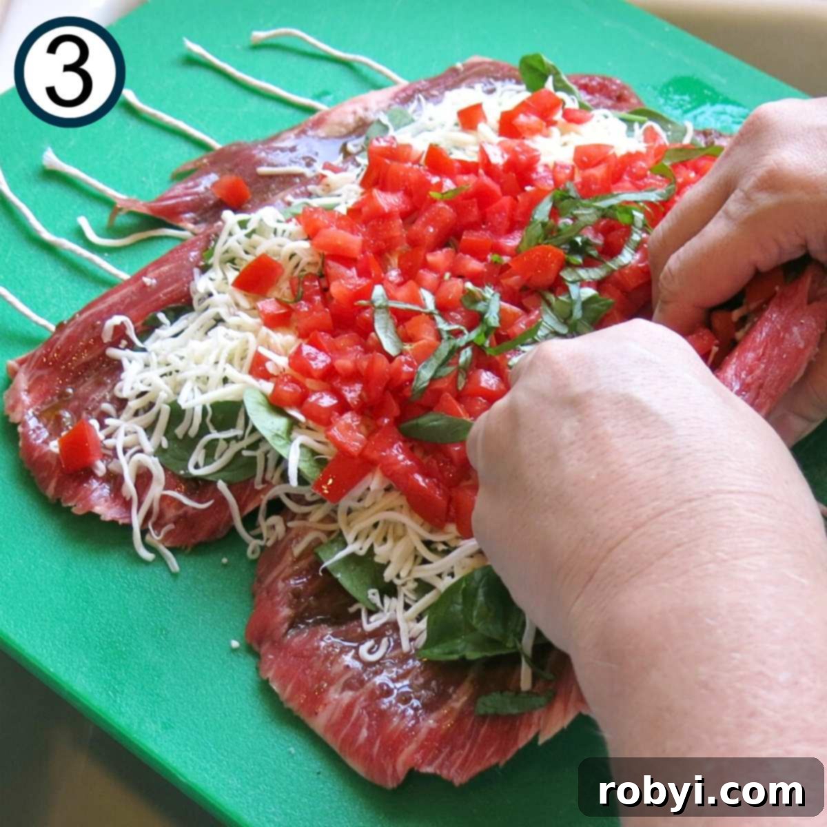 Hands rolling butterflied flank steak with toppings.