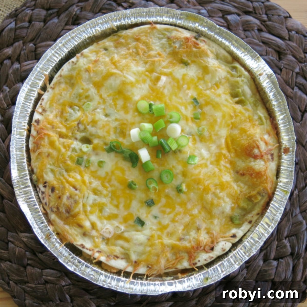 Repurpose Your Chicken Effortless Enchilada Bake 5 A golden-brown, cooked chicken enchilada pie in a round pan, fresh out of the oven.