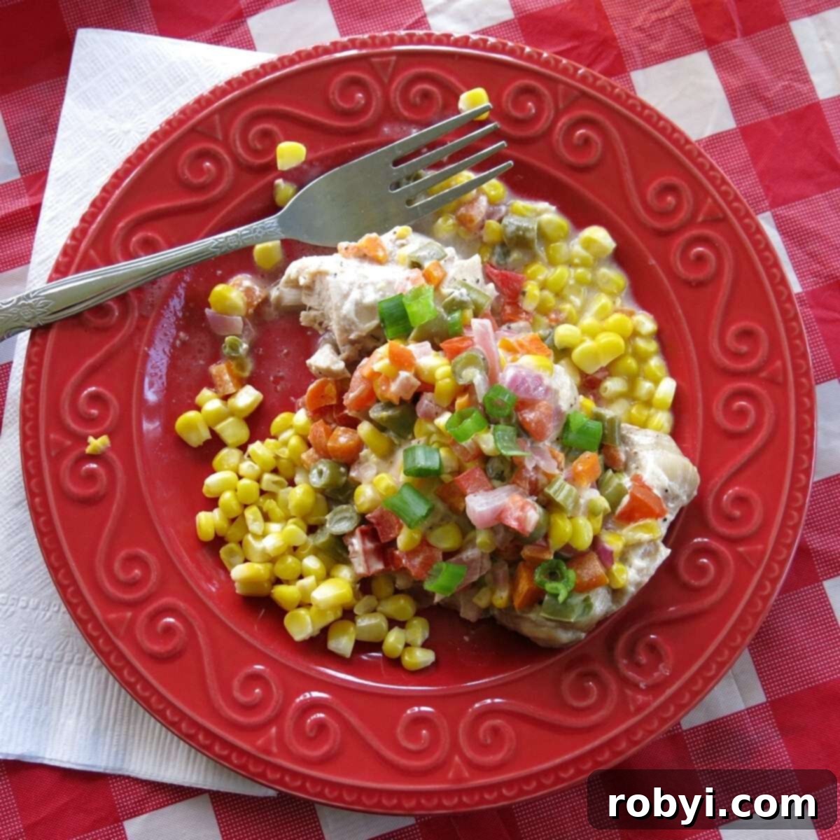 Ranch chicken topped with vegetables on a plate with a fork. 