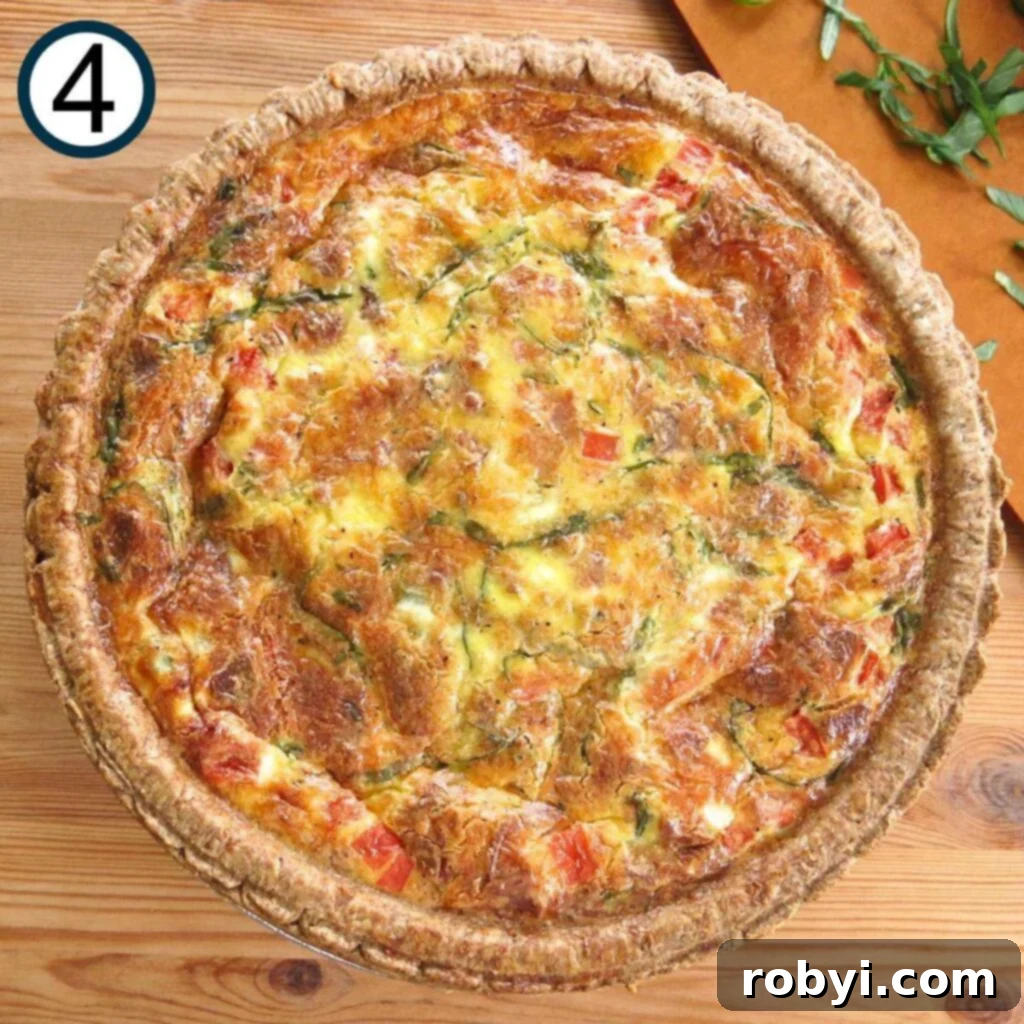 A freshly baked tomato bacon quiche resting on a butcher block counter, golden brown and perfectly set, cooling after coming out of the oven.