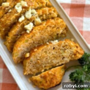 Buffalo chicken meatloaf sliced on platter and topped with crumbled blue cheese.