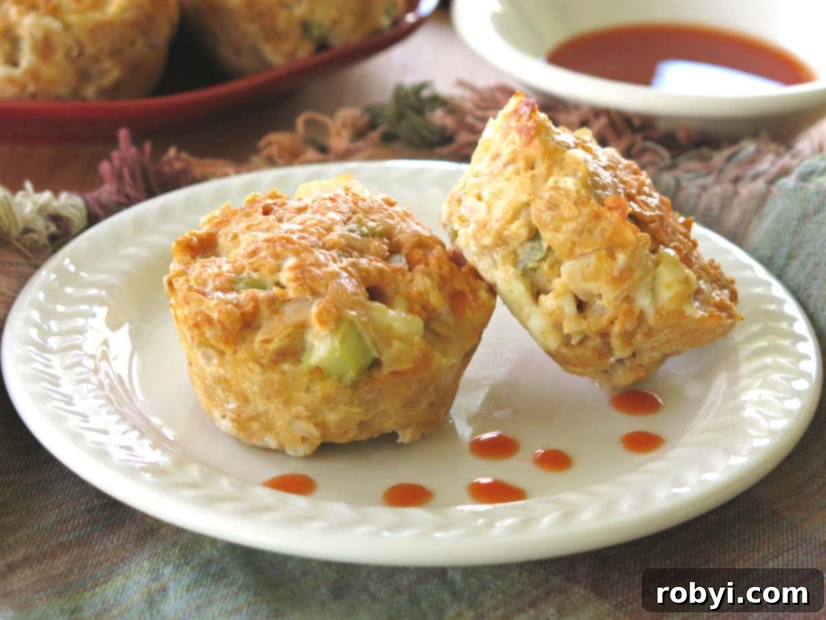 Two buffalo chicken meatloaf muffins on a plate with dots of buffalo wing sauce.