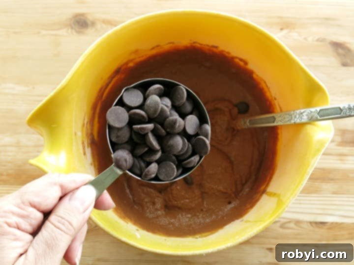 Dark Chocolate Chips in measuring cup over chocolate pumpkin batter.
