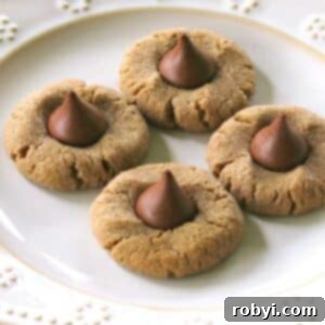 A plate of delightful 3-ingredient peanut butter blossom cookies, each perfectly crowned with a Hershey's Kiss, ready to be enjoyed.
