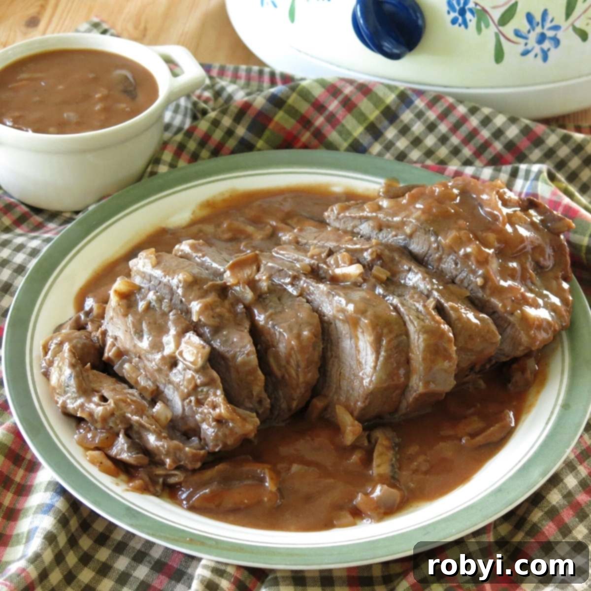 Sliced Beef Shoulder Roast cooked in a crock-pot with red wine mushroom sauce poured over the top.