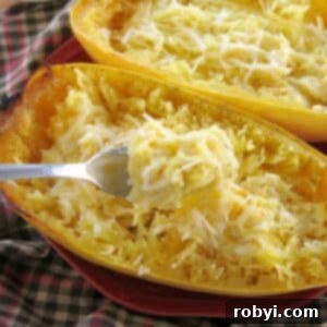 Fork lifting spaghetti squash alfredo out of gourd.