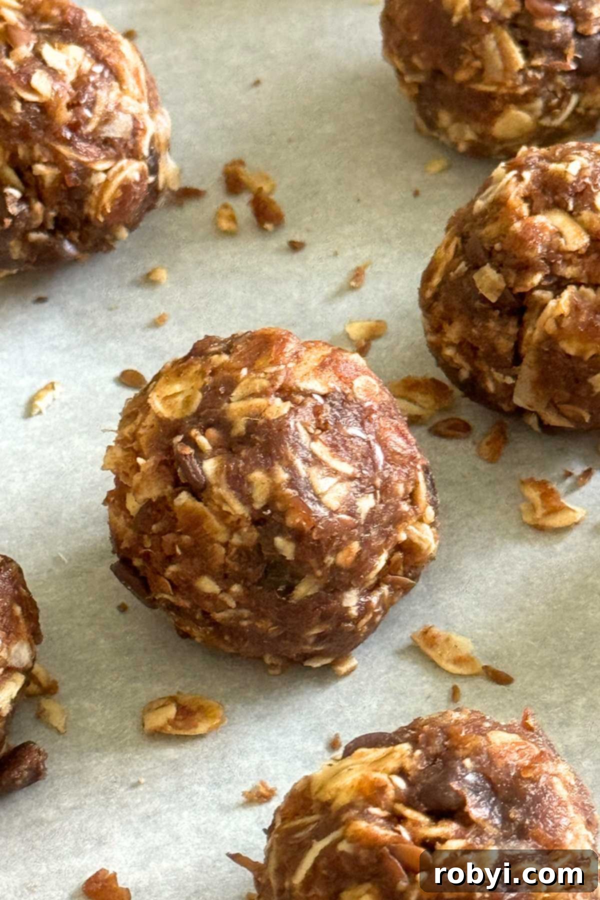 Energy balls made with Medjool dates and oats on parchment paper.