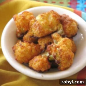 5-Ingredient Parmesan Cauliflower Poppers 7 A bowl of freshly cooked Parmesan Cauliflower Bites, garnished with a sprinkle of fresh parsley.