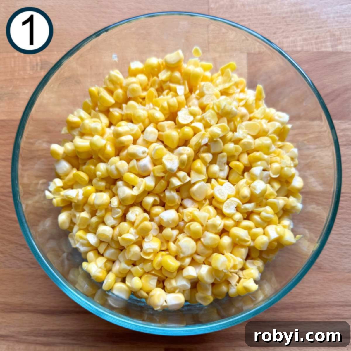 Creamy Elote Cups 4 Glass bowl with fresh corn kernels in it.