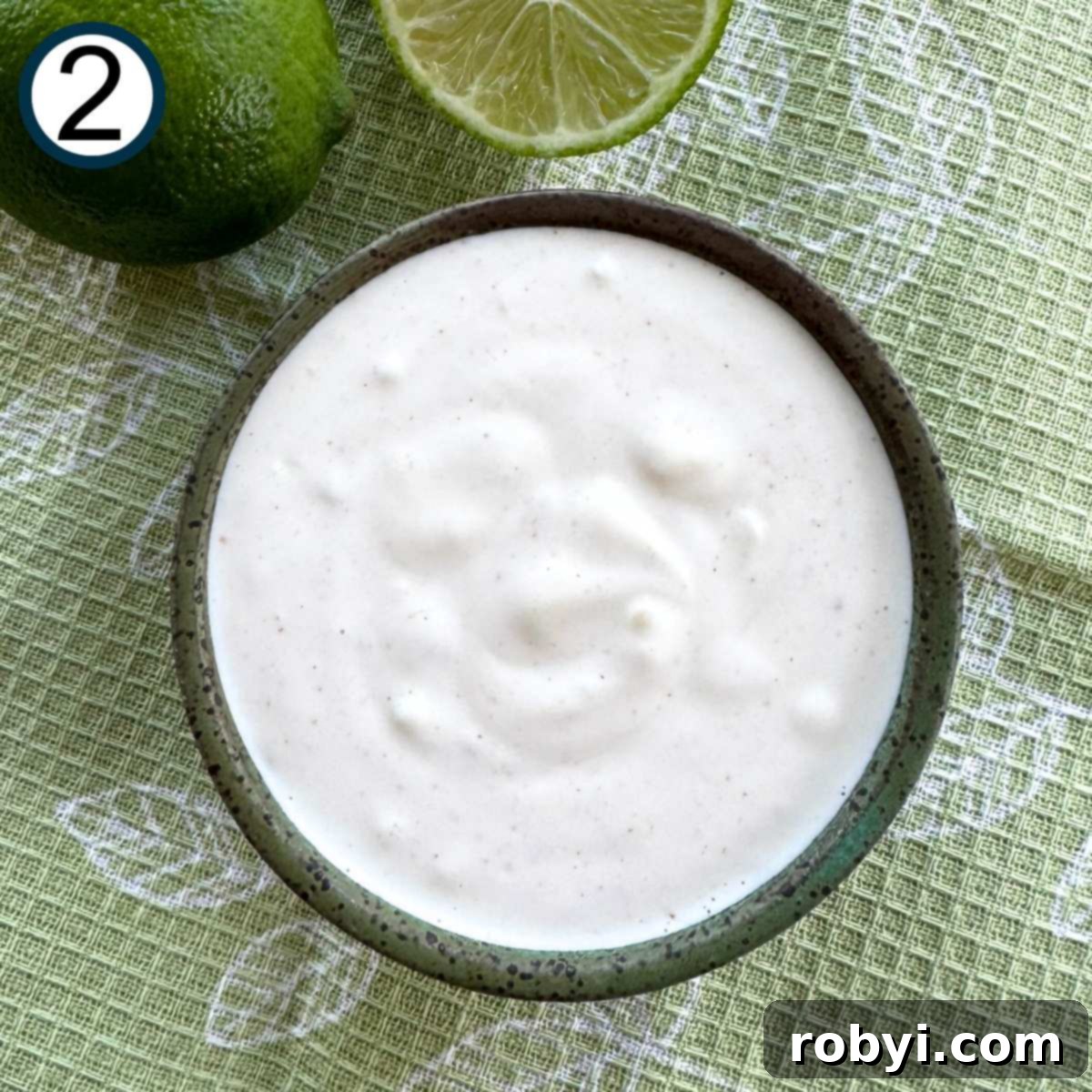 Creamy Elote Cups 5 Mixture of mayonnaise, sour cream, lime juice, pressed garlic, and cayenne pepper in a small bowl.