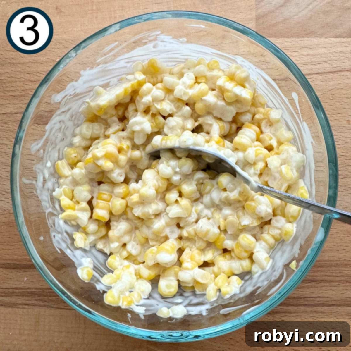 Creamy Elote Cups 6 Corn kernels mixed with lime crema mixture in a glass bowl.