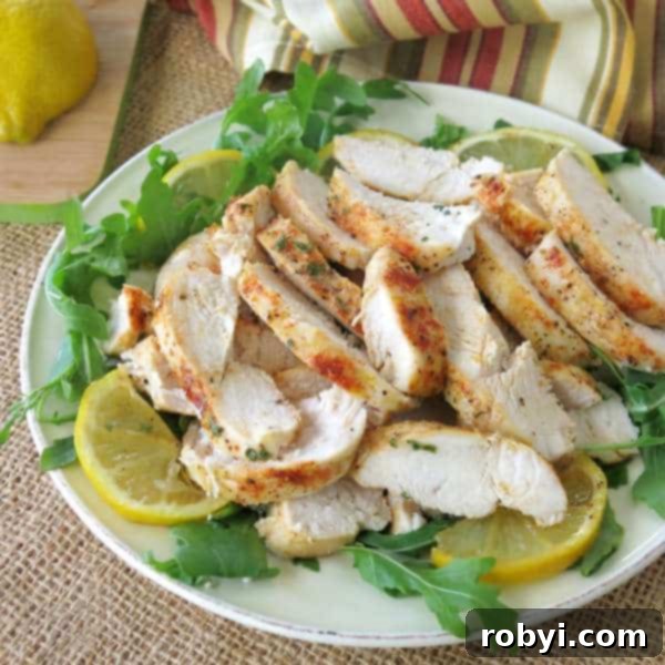 Healthy Baked Lemon Pepper Chicken sliced into perfect strips, served on a vibrant bed of mixed greens and garnished with fresh lemon wedges, showcasing its meal-prep potential.