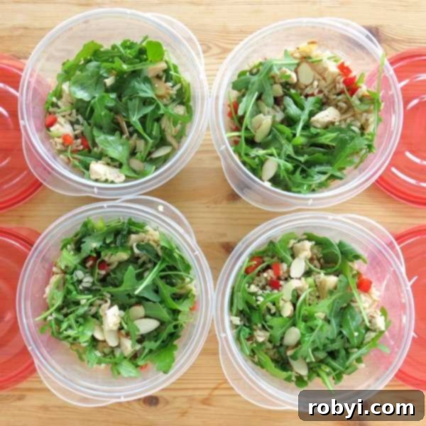 Cold Chicken Arugula Rice Salad in 4 containers next to lids for lunches.