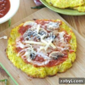 Spaghetti squash pizza crust cooked until crispy and topped with sauce, mushrooms, and cheese.