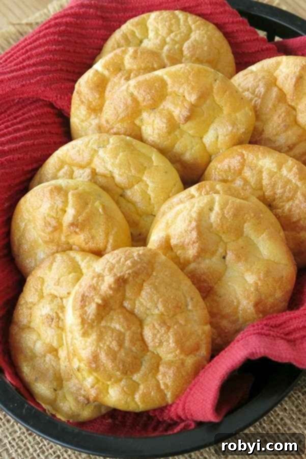 A basket filled with golden-brown, low-carb cloud bread made with ricotta cheese, lined with a rustic red cloth.