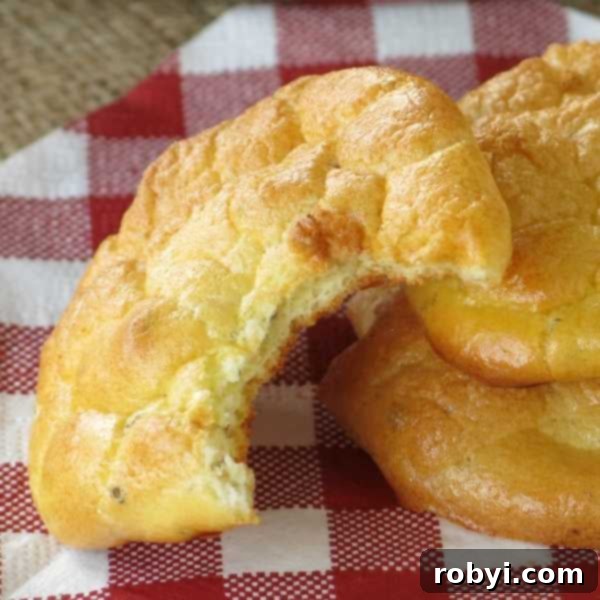 A piece of carb-free cloud bread, with a bite taken out, showcasing its fluffy and airy interior.