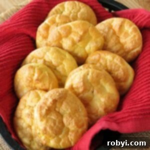 A basket of low-carb cloud bread made with ricotta, nestled in a basket lined with a vibrant red cloth.