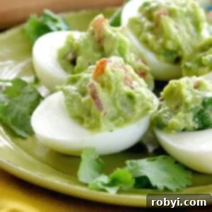 Beautifully presented Guacamole Stuffed Deviled Eggs, garnished and ready to be served as an appetizer.