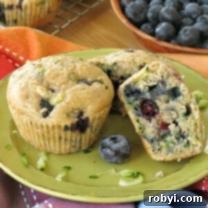 2 Zucchini Blueberry Muffins on plate with 1 cut in half