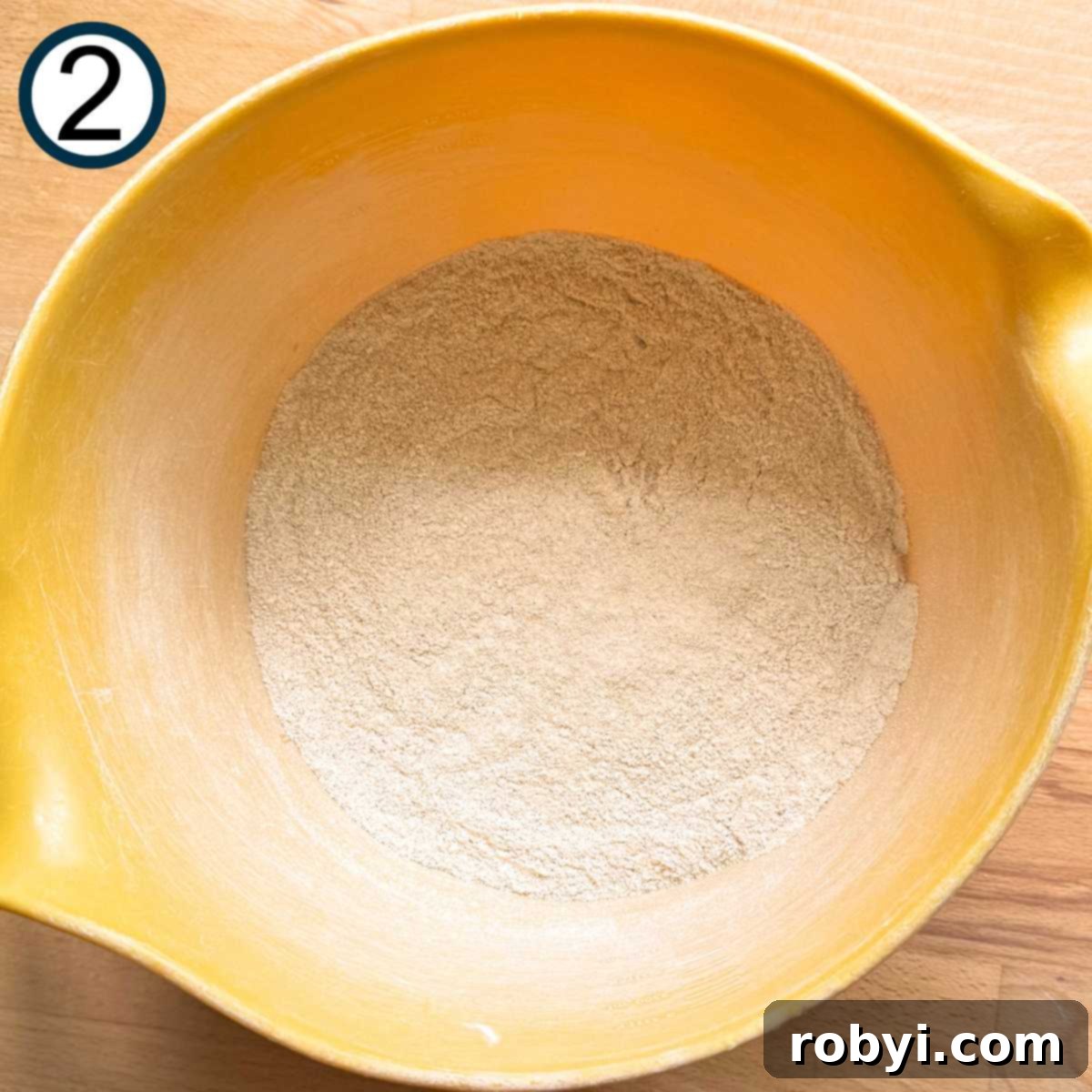 Flour, sugars, baking powder, baking soda, salt, and cinnamon in a large yellow bowl.