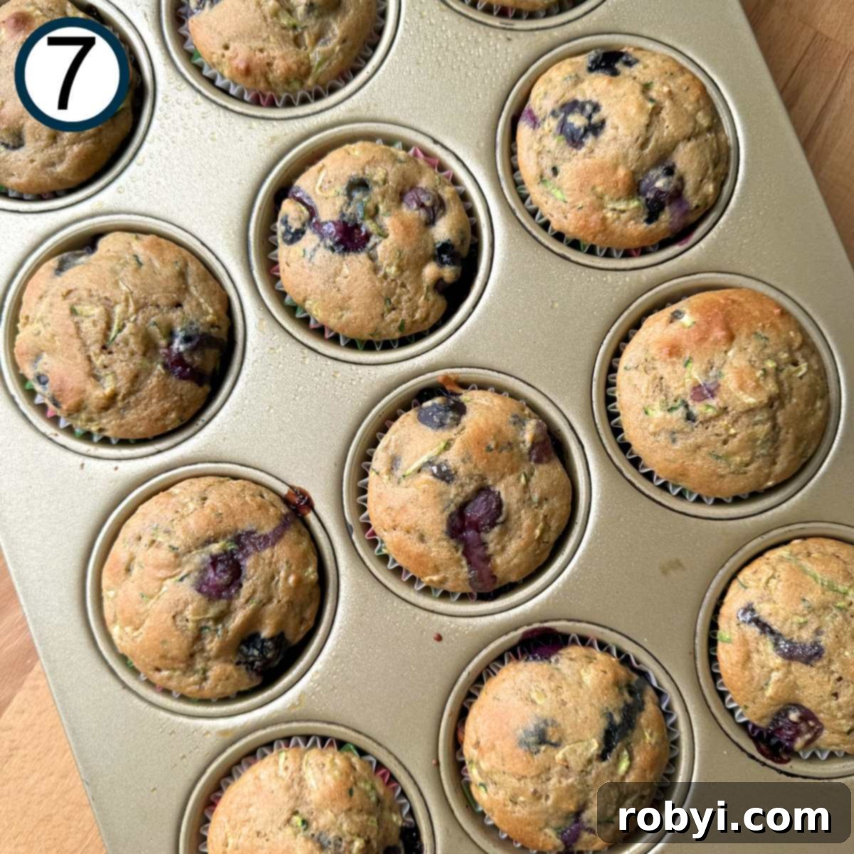 Cooked zucchini blueberry muffins in. a muffin pan.