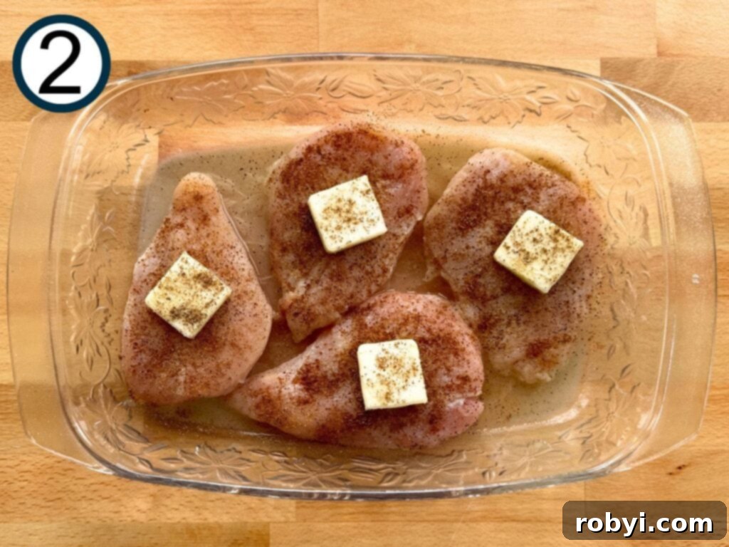 Glass dish with four chicken breasts seasoned with lime, butter, garlic powder, and Tajin.