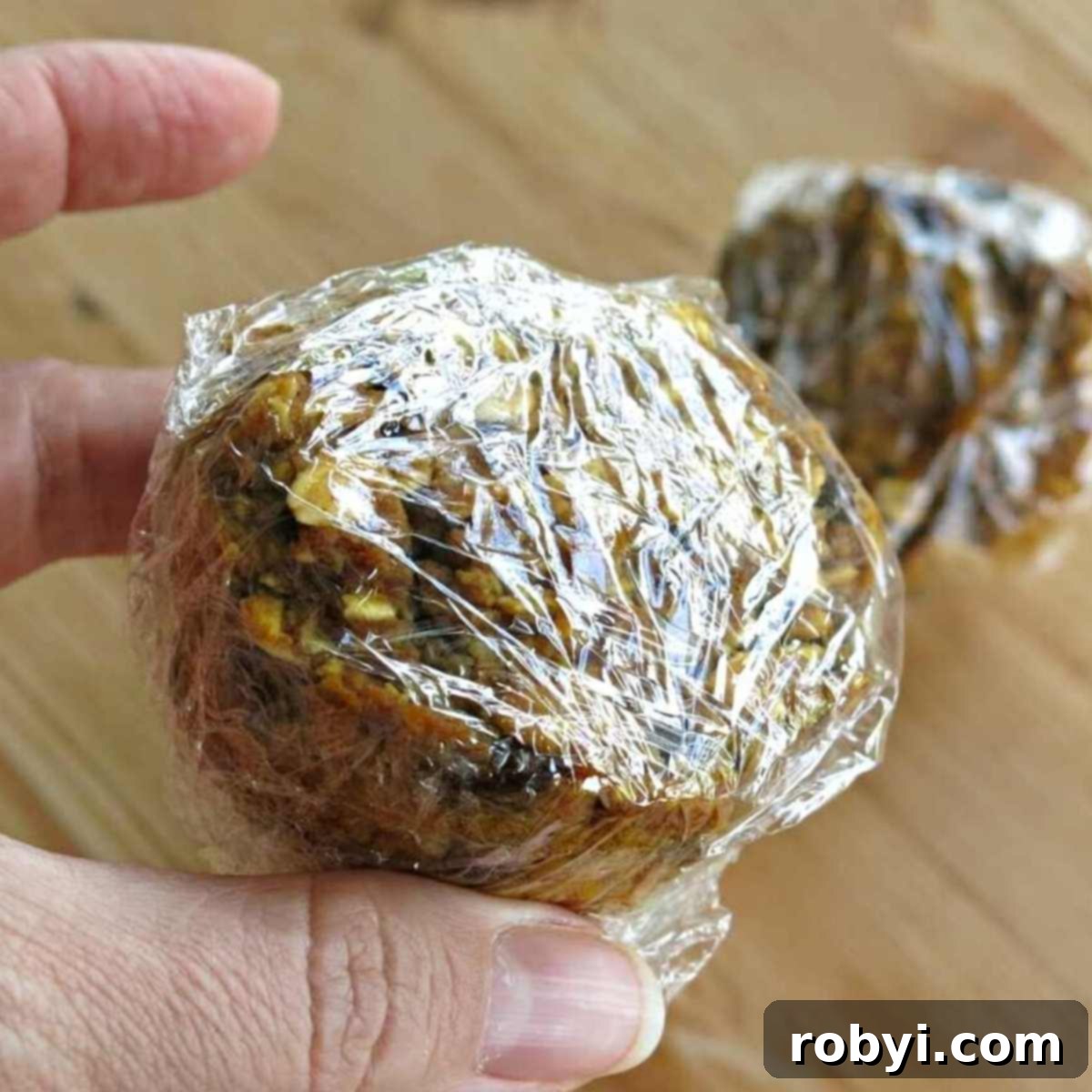 Oatmeal Pumpkin Muffin wrapped in plastic wrap, ready for freezing or storage.