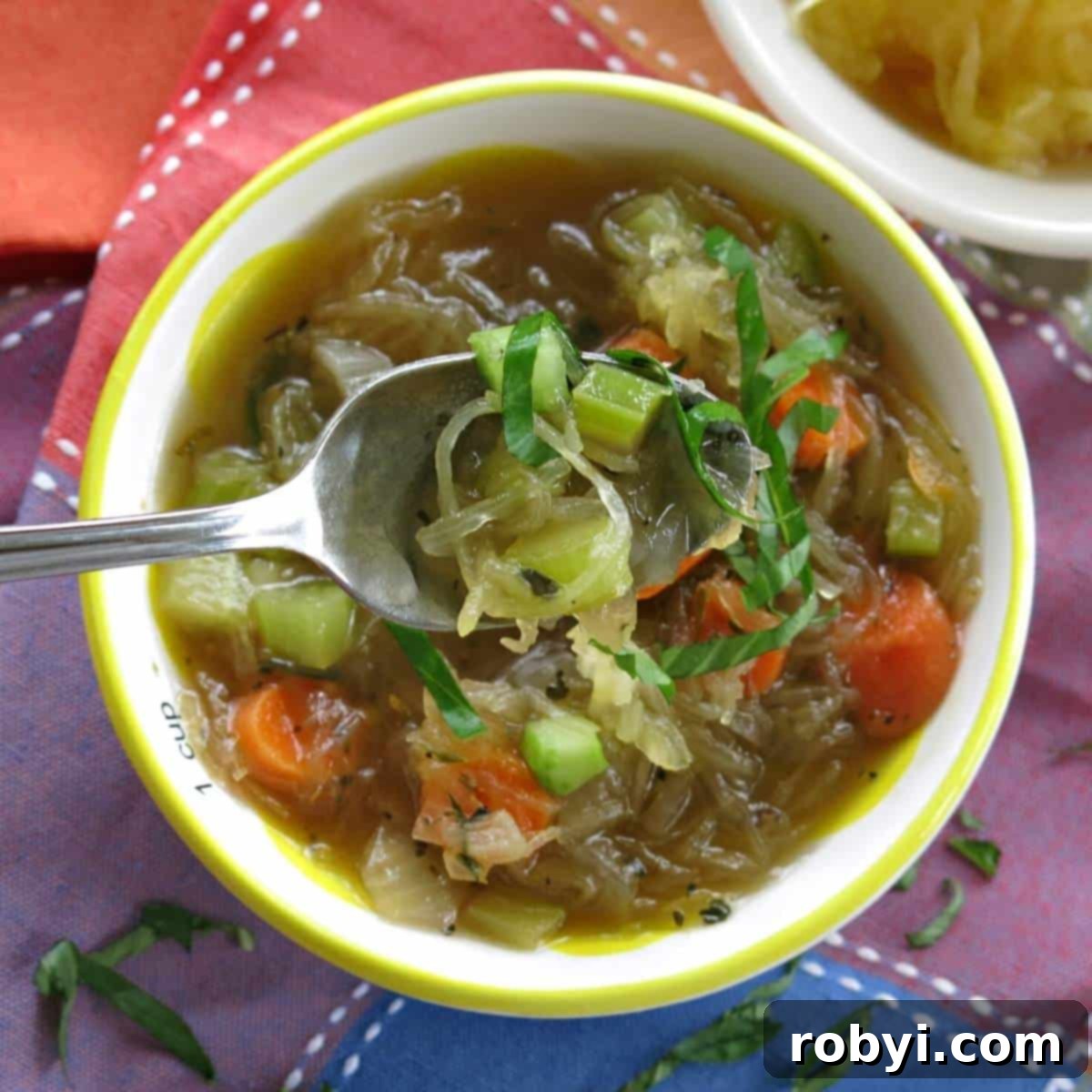 Spoon lifting up some spaghetti squash vegetable soup.