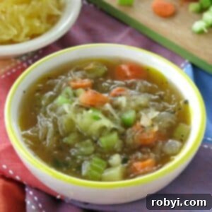 Easy spaghetti squash soup in a bowl with a bowl of spaghetti squash and cut vegetables behind it.