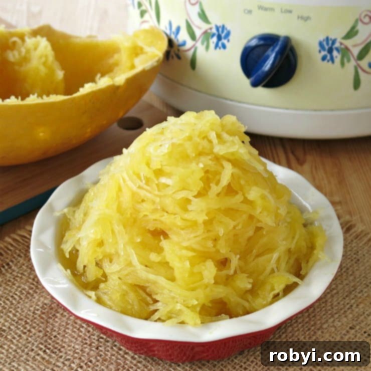 Cooked whole spaghetti squash in a bowl in front of a slow cooker, ready to be served as a healthy, low-carb meal.