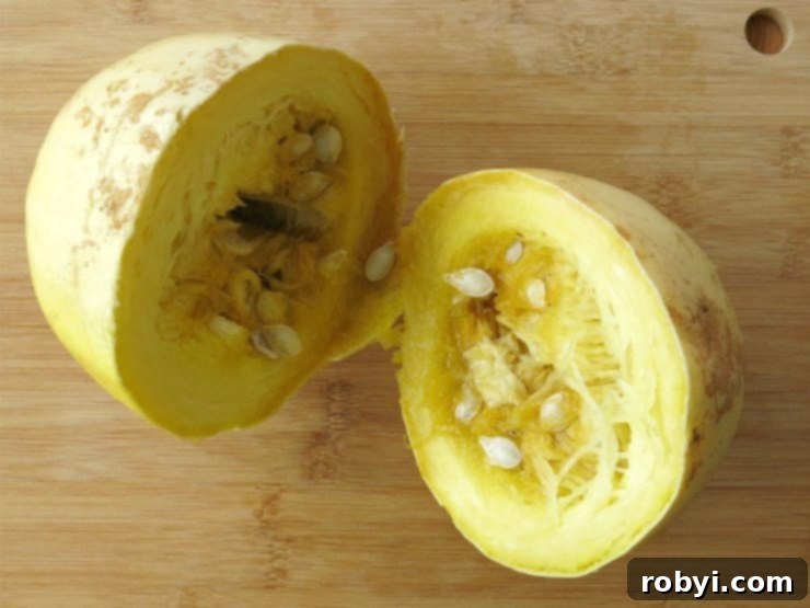 Spaghetti squash cut in half crosswise, revealing long, continuous strands resembling pasta noodles.