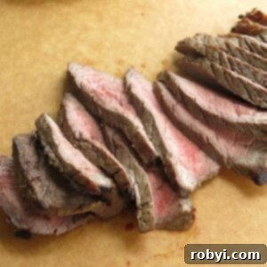 The Ultimate Oven-Baked London Broil 9 Sliced london broil on cutting board.
