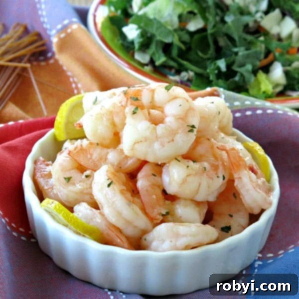 A bowl of perfectly cooked skillet shrimp, served alongside a fresh green salad and a side of pasta.