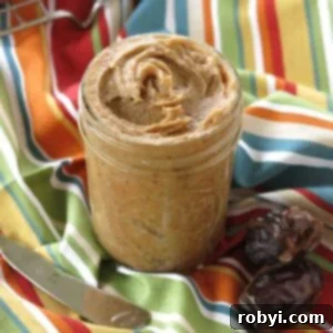 Jar of homemade date jam with 2 Medjool dates and a knife next to it.