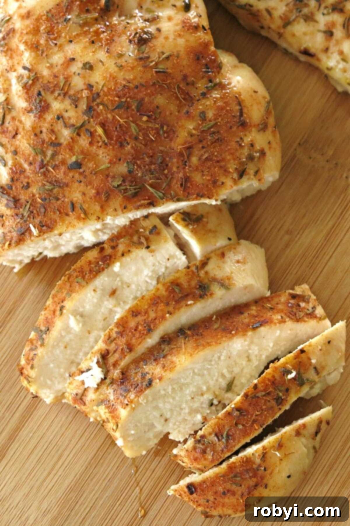 Spicy Oven-Roasted Chicken Breasts 4 Beautifully oven-baked blackened chicken sliced on a rustic cutting board, showcasing its juicy, tender interior and rich spice crust.