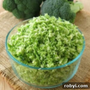 Bowl of riced broccoli with heads of broccoli behind it.