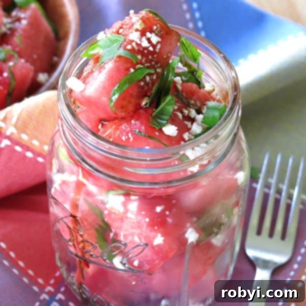 A refreshing Watermelon Basil Feta Salad served in a mason jar, with a fork resting beside it, ready to be enjoyed.