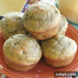 Butternut squash muffins with apple stacked on a plate, garnished with cinnamon and walnuts.