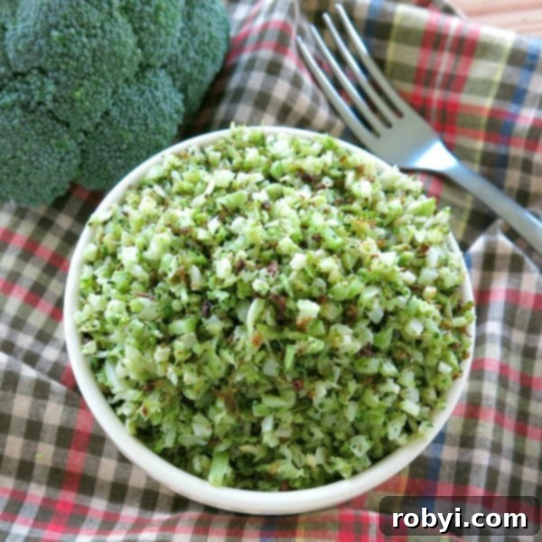 Roasted broccoli rice in a bowl next to a head of broccoli and a fork