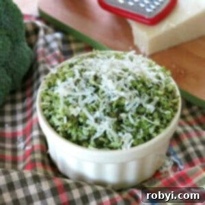 Roasted broccoli rice topped with Parmesan cheese in a bowl with broccoli and cheese in the background