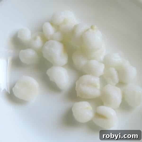 Close-up of hominy kernels on a white plate, showcasing their unique texture.