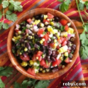 Fresh corn and black bean salsa with red wine vinegar dressing in a wooden bowl.
