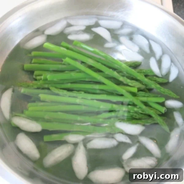 Blanched asparagus in bowl with ice.