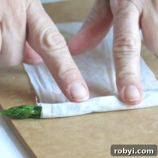 Asparagus being rolled in phyllo dough.