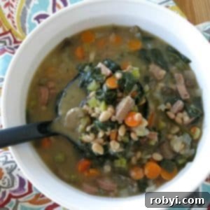Ladle lifting white bean, sausage and spinach soup from bowl