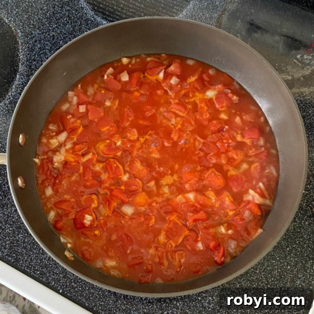 Sizzling Skillet Greek Shrimp with Burst Tomatoes and Crumbled Feta 3 Tomatoes, onions, garlic and red wine vinegar in skillet before simmering to reduce liquid.