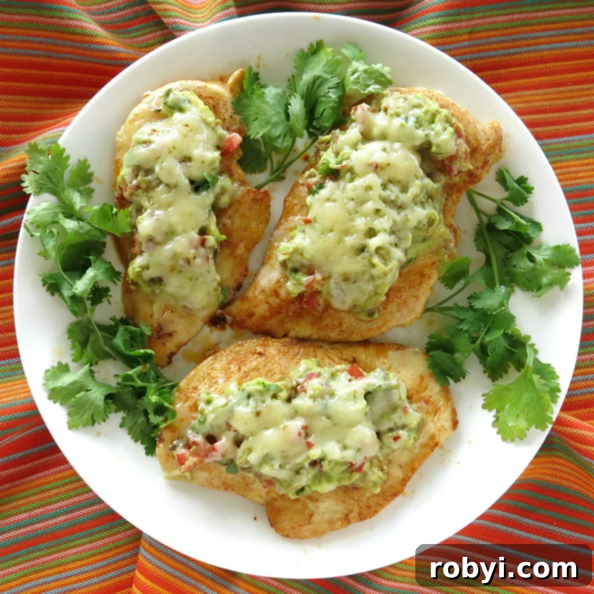 Guacamole chicken melts on a plate surrounded by cilantro