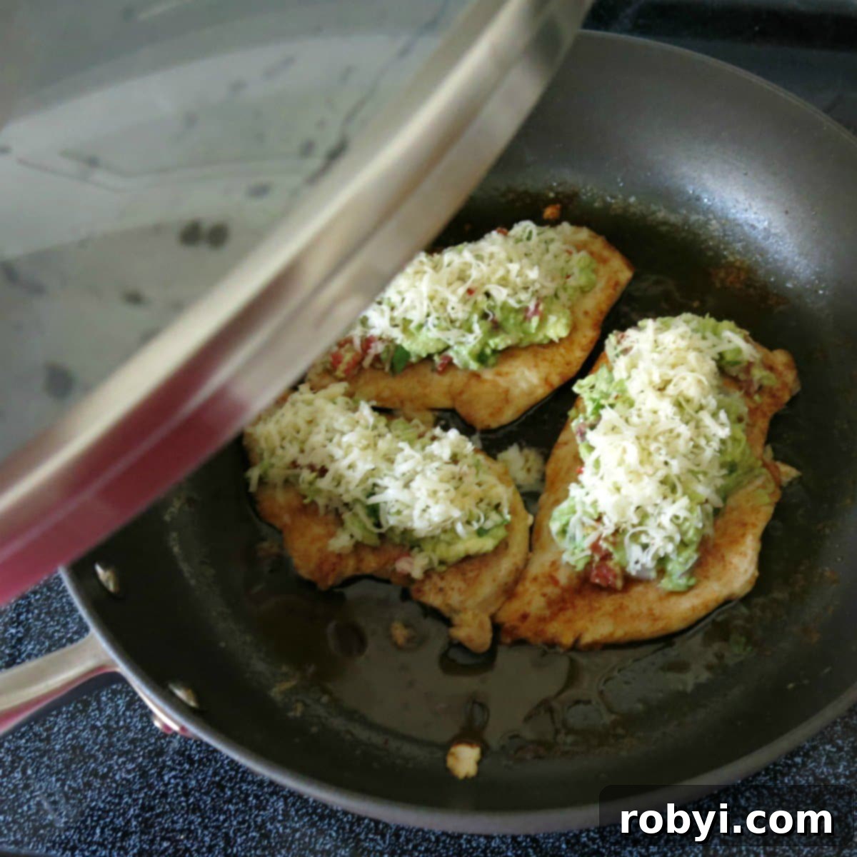 Chicken guacamole in pan before cheese has melted with lid being placed on top
