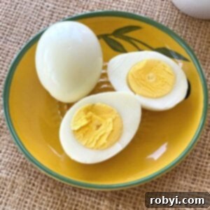 Easy Air Fryer Hard Boiled Eggs for All Models 6 Two hard-boiled eggs cooked in a Ninja Air Fryer. One is whole, the other cut in half.